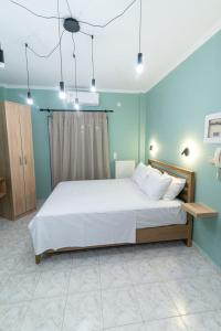 a bedroom with a large white bed with blue walls at FVK Apartments in Preveza
