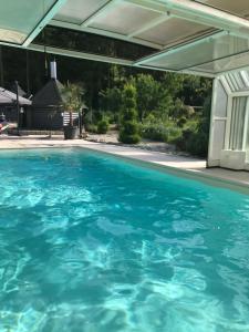 an outdoor swimming pool with blue water at Logis Hôtel DOMAINE du MOULIN in Saint-Avold