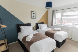 1 dormitorio con 2 camas y ventana en Perfect for Contractors & Families + Free Parking + Wifi, en Stafford
