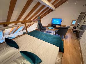 ein Wohnzimmer mit einem Bett und einem TV in der Unterkunft Chez Alain Prévu - Boutique Hotel by Stay Swiss in Pruntrut
