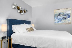 1 dormitorio con cama blanca y cabecero azul en Cozy Studio in the Heart of Downtown Kimmswick, 