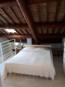a bedroom with a white bed with a wooden ceiling at Ca' Santina in Cittadella