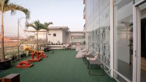 einen Balkon mit Stühlen und einen Spielplatz an einem Gebäude in der Unterkunft Solia Hotel Yosodipuro in Solo