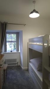 um quarto com um beliche e uma janela em Bobtail Cottage by Woodland Park em Staveley