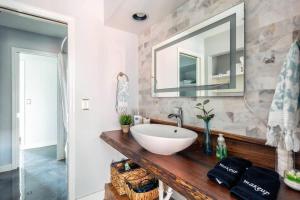 a bathroom with a sink and a mirror at Walk To Broadway Charming Modern Historic Townhome in Nashville