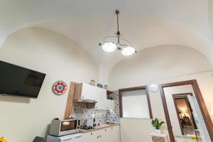 uma cozinha com paredes brancas e 2 tectos abobadados em Catania Easy Center Home em Catânia