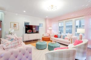 a living room with pink and white furniture and a tv at Butterfly BNB~Modern Luxury~Giant Rooftop~9Min DT in Nashville