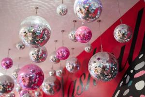 a bunch of disco balls hanging from a wall at Butterfly BNB~Modern Luxury~Giant Rooftop~9Min DT in Nashville