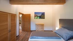 a bedroom with a bed and a dresser at Beim Schwarzmarl - Your Austrian Home in Bad Aussee +24 photos