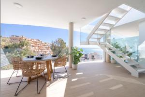 Un comedor con mesa y sillas en un balcón. en Higuerón Rental Wave&Sun, en Fuengirola