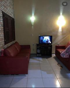 ein Wohnzimmer mit 2 Sofas und einem Flachbild-TV in der Unterkunft Sitio vó Dora in Aratuba
