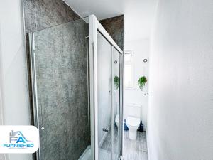 a bathroom with a glass shower and a toilet at Modern House - Great Location - Free Parking in Headingley