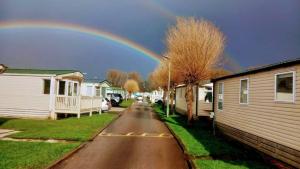 a rainbow in the sky over a street with houses at regent bay in Morecambe