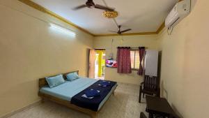 a bedroom with a bed and a ceiling fan at Coco Hut , Devbaug in Malvan