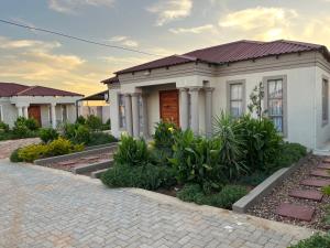 a house with a brick driveway in front of it at Mafikeng Boutique Lodge in Mahikeng