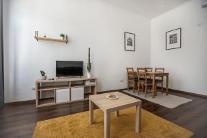 ein Wohnzimmer mit einem TV, einem Tisch und Stühlen in der Unterkunft Classy Creation Apartment in Budapest
