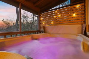 une baignoire jacuzzi dans une chambre avec fenêtre dans l'établissement Mountain Views Hot Tub FirePit Close to town, à Blue Ridge