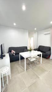 uma sala de estar com uma mesa branca e um sofá em Encantador Apartamento en Lebrija em Lebrija