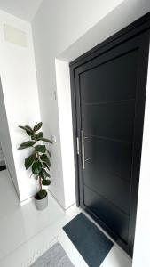 czarne drzwi w pokoju z doniczką w obiekcie Encantador Apartamento en Lebrija w mieście Lebrija