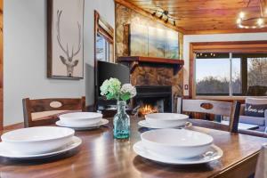 a dining room table with plates and a vase of flowers at Mountain Views Hot Tub FirePit Close to town in Blue Ridge