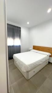 um quarto branco com uma grande cama branca em Encantador Apartamento en Lebrija em Lebrija