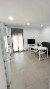 a kitchen and living room with a refrigerator and a table at Encantador Apartamento en Lebrija in Lebrija