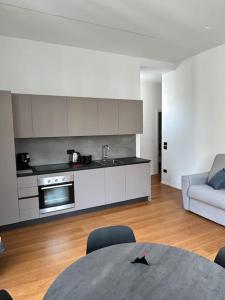 a kitchen and living room with a table and a couch at Loft Metro Mergellina in Naples