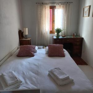 ein Schlafzimmer mit einem weißen Bett und Handtüchern darauf in der Unterkunft Quinta dos Malhadais, Figueira - Farm house in Portimão