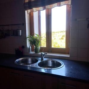 a sink in a kitchen with a window at Quinta dos Malhadais, Figueira - Farm house in Portimão