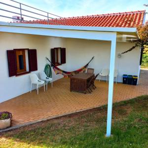 eine Terrasse mit einem Tisch und Stühlen in einem Haus in der Unterkunft Quinta dos Malhadais, Figueira - Farm house in Portimão