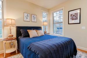 a bedroom with a blue bed with two windows at Game Room ~ Fire Pit ~ Resort Access ~ Huge Home in Lake Lure +31 photos