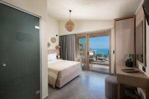 een slaapkamer met een bed en uitzicht op de oceaan bij Castaway Suites - Studios Christos in Limenaria