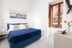 sypialnia z niebieskim łóżkiem i oknem w obiekcie YourHome - Jolly Aranci w Sorrento