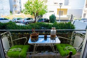 a table and chairs on a balcony with two candles at sophia's apartment in Volos