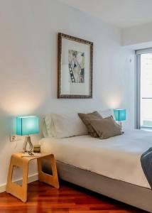 een slaapkamer met een bed en een tafel met 2 lampen bij Canela Homes BARCELONA DIAGONAL MAR in Barcelona