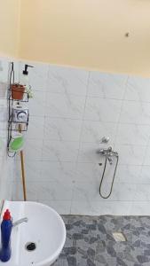 y baño con ducha, aseo y lavamanos. en Kichunguu FarmStay Cottage, en Oloitokitok 