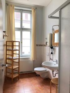 a bathroom with a toilet and a sink and a window at 6 Ferienwohnung - Ferien Mittendrin in Schwerin