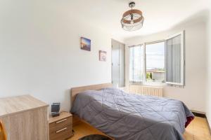 Schlafzimmer mit einem Bett, einem Schreibtisch und einem Fenster in der Unterkunft villa jasmin in Saint-Laurent-la-Vernède