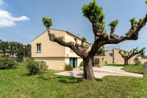 ein Haus mit einem Baum davor in der Unterkunft villa jasmin in Saint-Laurent-la-Vernède
