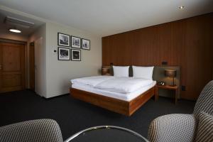 ザンクト・マルティンにあるConsulat des Weinsのベッド1台と椅子2脚が備わるホテルルームです。