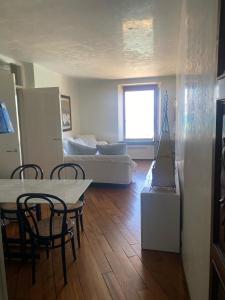 a living room with a couch and a table and chairs at Azzurra, sulla Calata di Portovenere in Portovenere