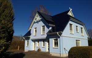 Biały dom z czarnym dachem w obiekcie Haus Ostseezwilling 2 w Zingst