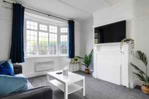 salon z kanapą i telewizorem w obiekcie Livestay 3 Bed House in Hendon Private Garden&Parking w mieście Colindale