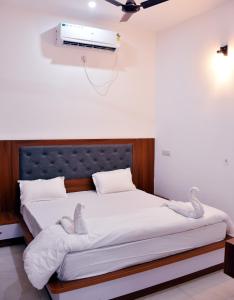 1 dormitorio con 1 cama grande y ventilador en Advent Hotel, en Sūrajpur