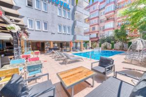 an outdoor patio with chairs and a swimming pool at Kleopatra ICARIA Apart Hotel in Alanya