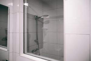 La salle de bains est pourvue d'une douche avec une porte en verre. dans l'établissement Sweet Water Caminito del Rey, à Carratraca