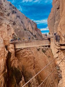 a bridge over a canyon with a bunch of people on it at Sweet Water Caminito del Rey in Carratraca