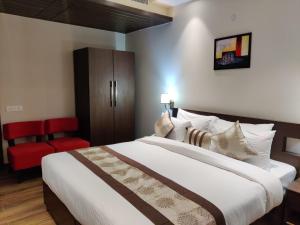 a bedroom with a large bed and a red chair at Nature's Nest in New Delhi