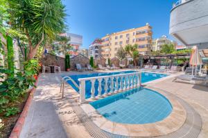 a swimming pool in a resort with tables and chairs at Kleopatra ICARIA Apart Hotel in Alanya