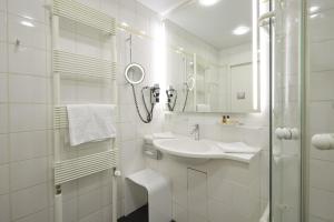 a white bathroom with a sink and a shower at Consulat des Weins in Sankt Martin